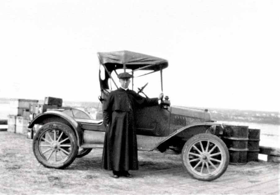 Denis Doucet standing beside his car